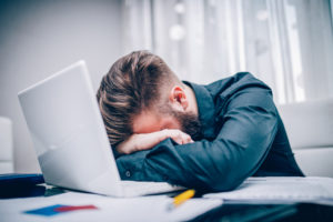 Young businessman getting tired and depressed working hard in the office